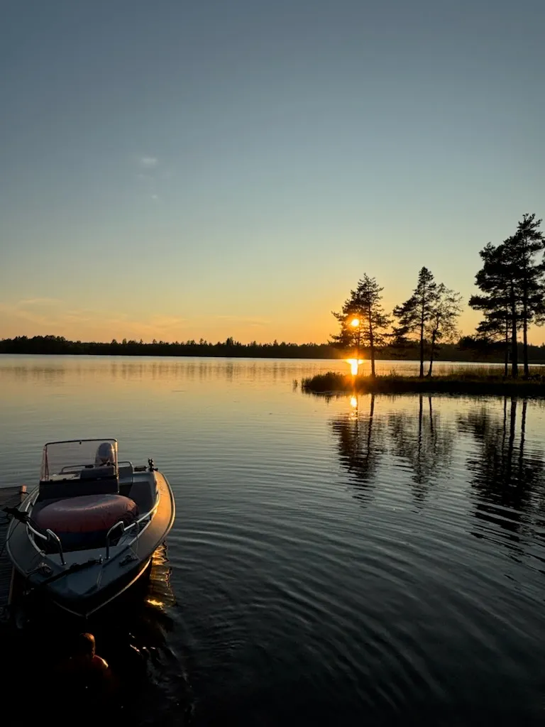 Motorboat moored on the Dalälven at sunset.