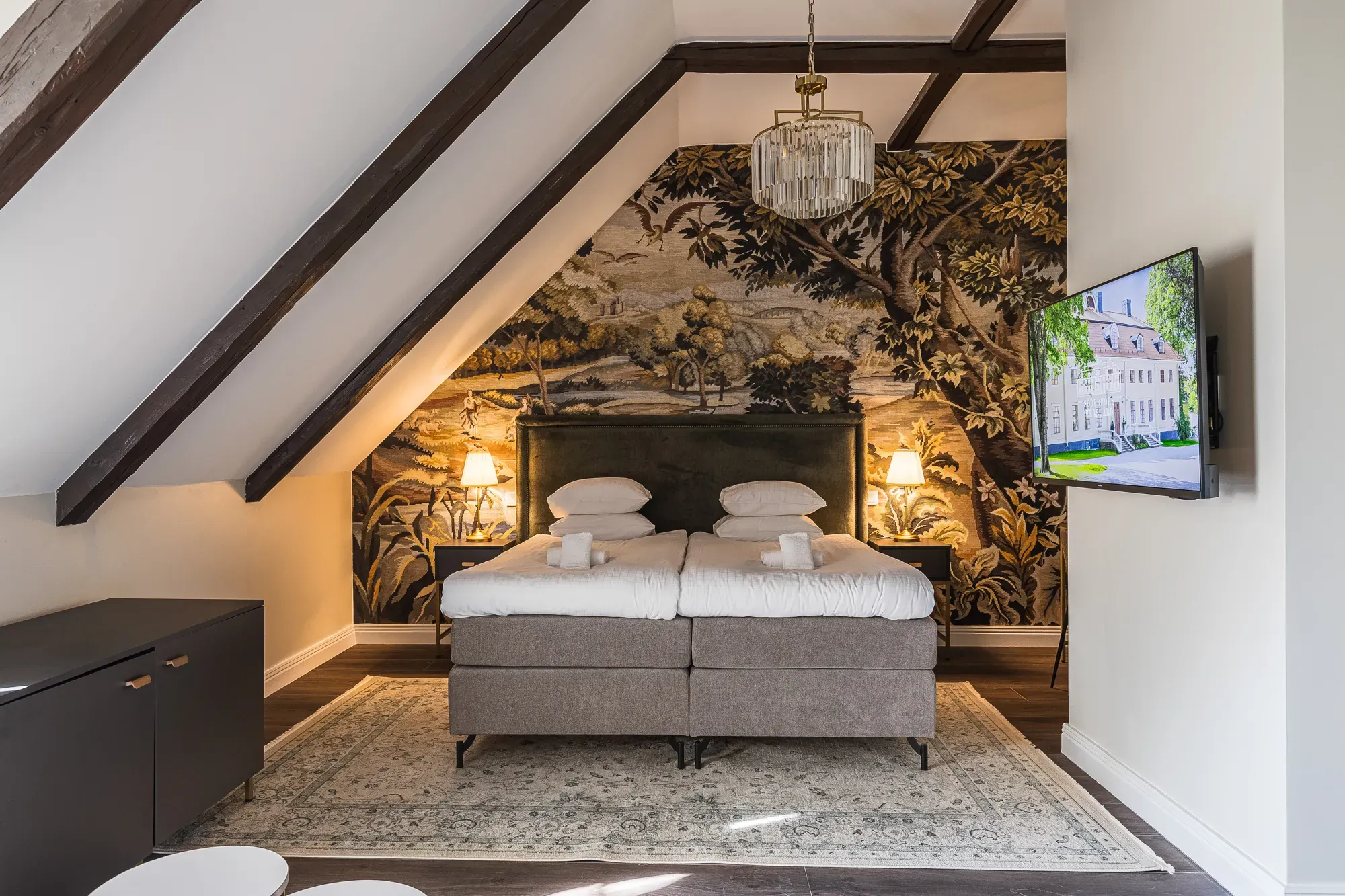 Ein Hotelzimmer mit sichtbaren Balken und Doppelbett.