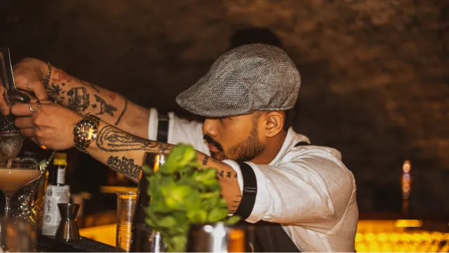 A bartender prepares a mint drink at the bar.