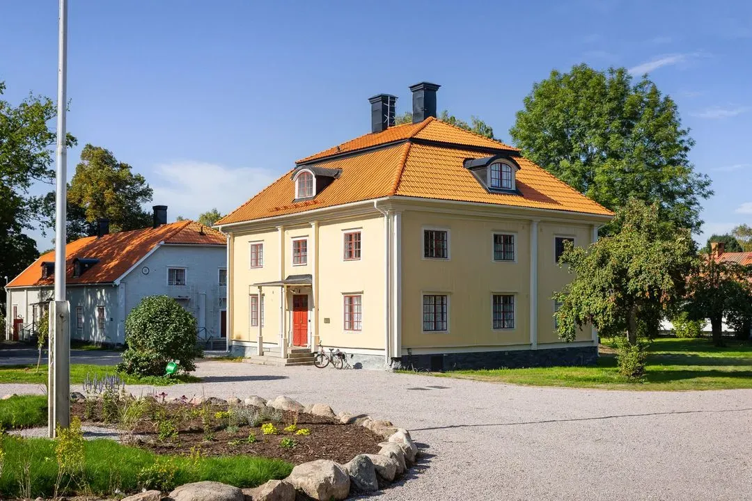 Der gelbe Flügel Brukshuset mit Eingang und Garten.