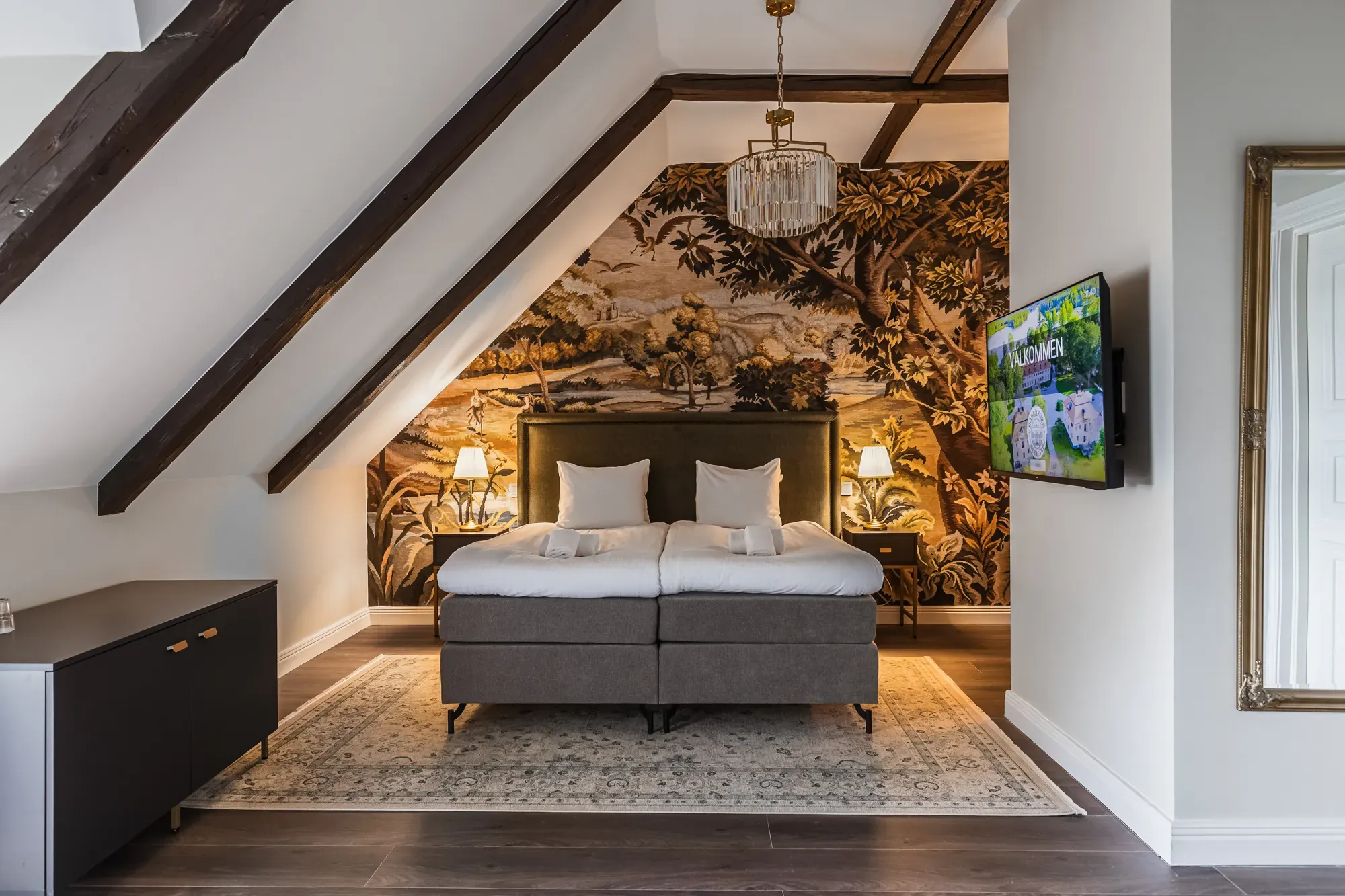 Renovated hotel room with exposed beams and a patterned feature wall.