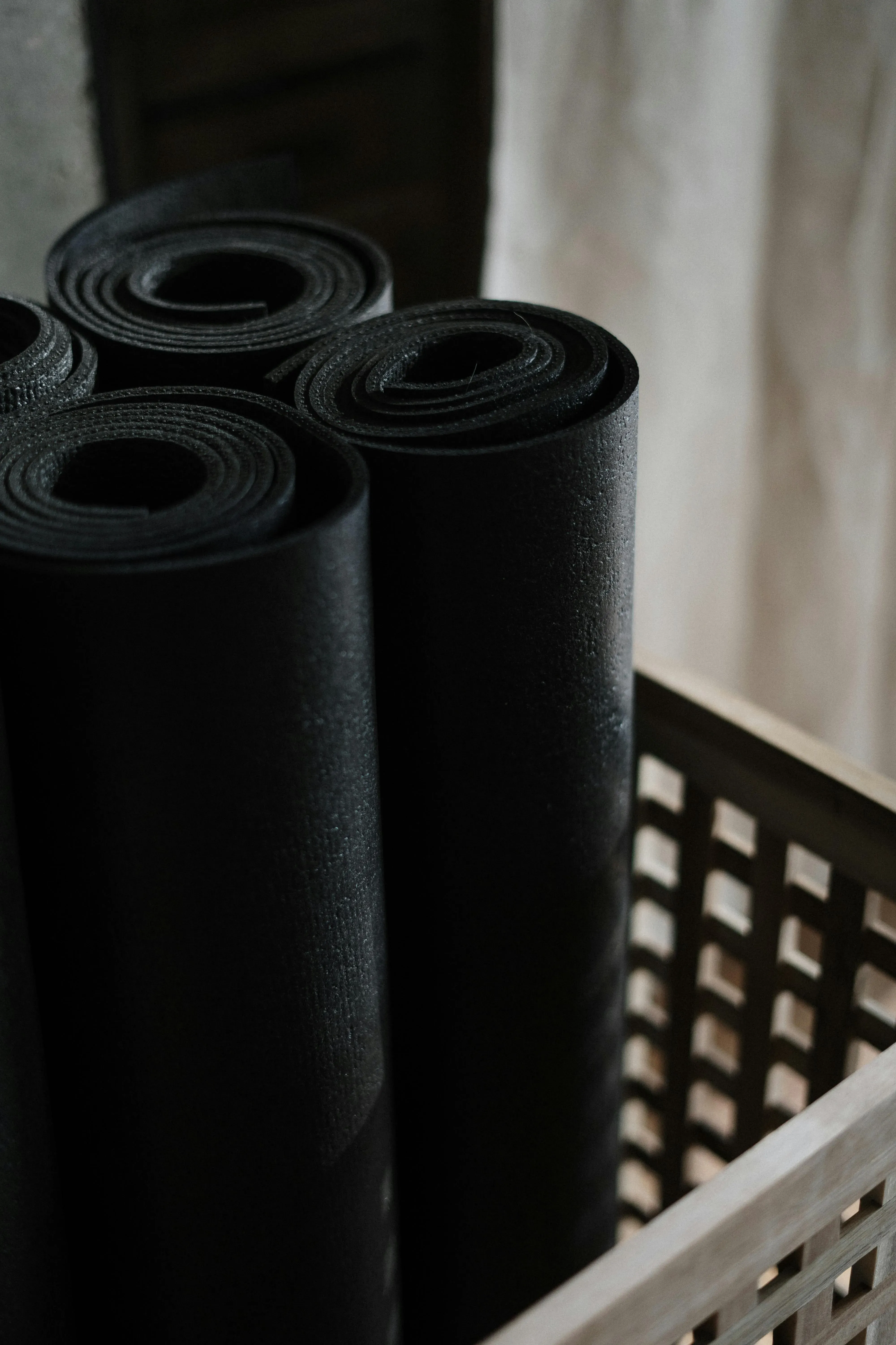 Gerollte Yogamatten in einem Korb.